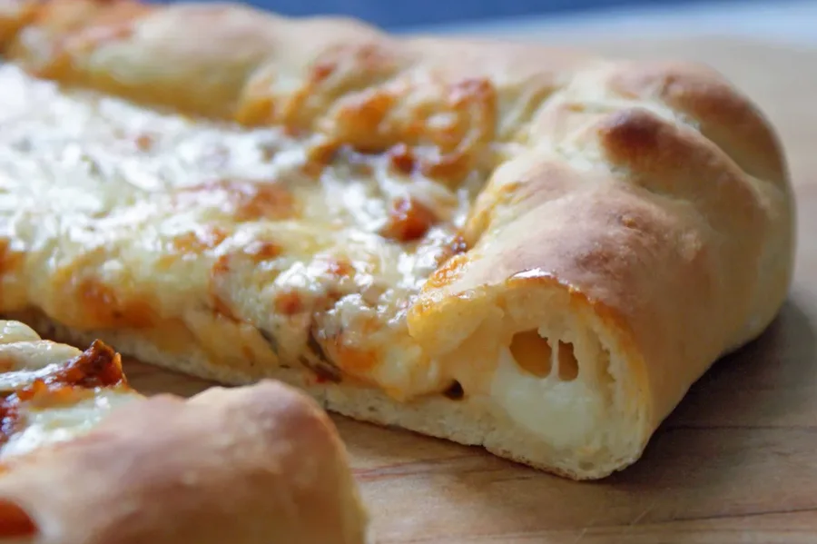 Stuffed pretzel crust pizza fresh from the oven with a thick golden crust